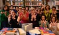 A group of women each holding up their fingers and thumbs to make a 'W' shape