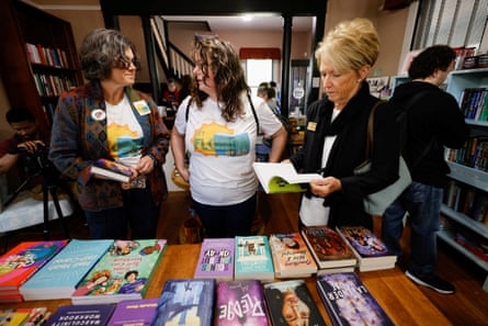Three women looking at books on a table