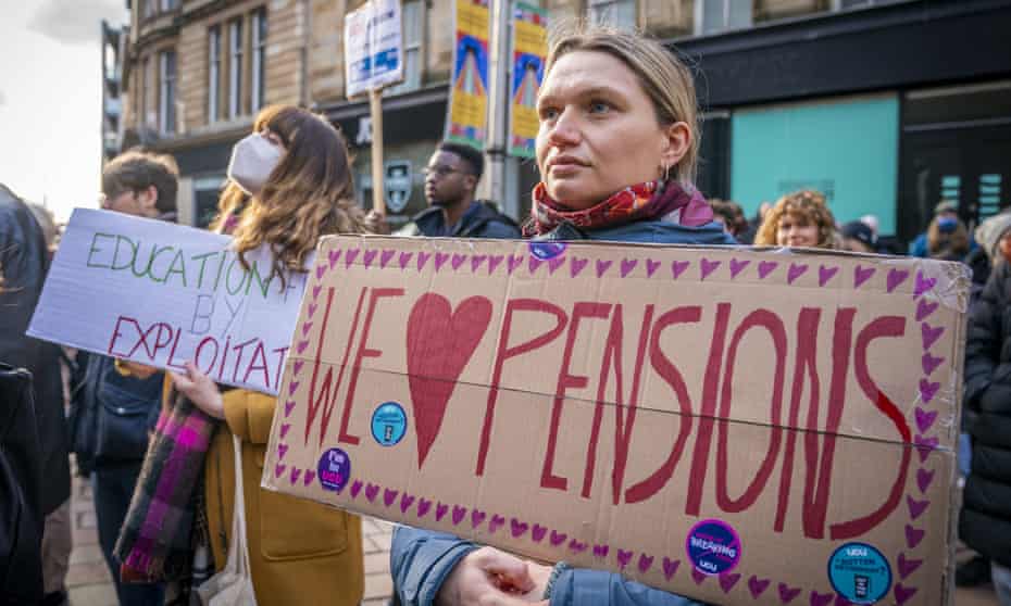 Protesters hold banners in support of pensions and pay