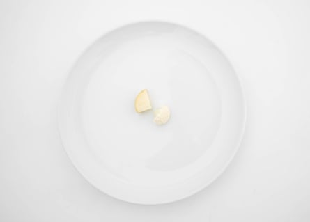 Overhead shot of a white plate with a small wedge of potato and cauliflower