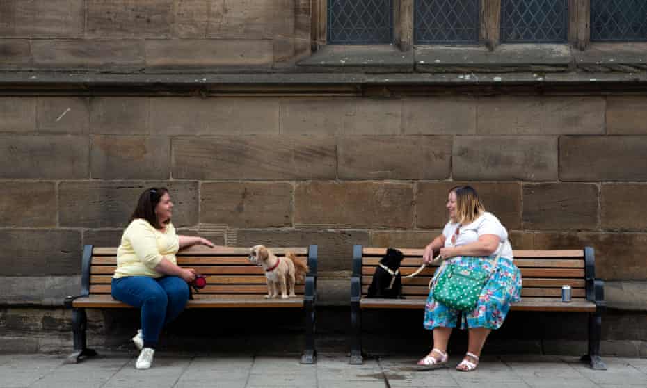 Dog-walkers observe social distancing while meeting up on a street in York.