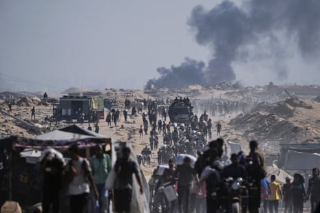 Palestinians carry sacks of flour unloaded from a humanitarian aid convoy on the outskirts of Beit Lahiya.