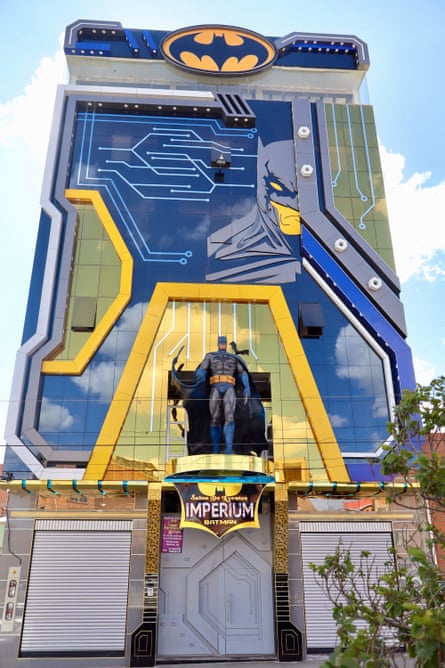 a futuristic building with a statue of batman outside