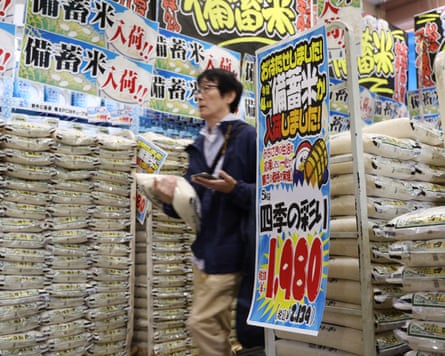 A customer walks past sacks of rice, released by the government from its reserve under a discretionary contract, at a branch of Japanese discount retailer Don Quijote.