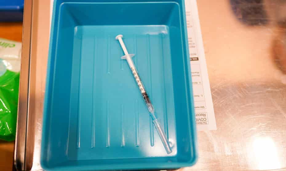 Syringe of Covid vaccine in tray at school