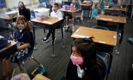 Students wearing protective mask attend class on the first day of school at St Lawrence Catholic school in North Miami Beach, Florida, this week. Several counties are defying the governor’s ban on mask mandates.