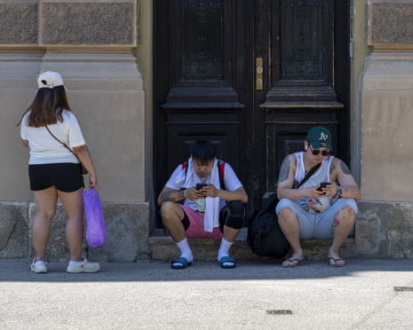 People shelter from the sun in the shadow of a building during sunny and hot weather as heatwave affecting Europe reaches Zagreb, Croatia.