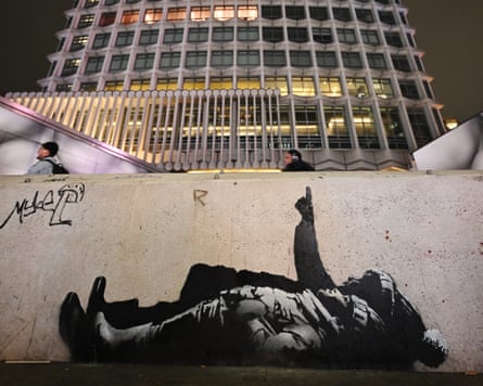 A mural shows two children lying on their backs and looking at the sky, as one child points upwards. Beyond is the Centre Point tower