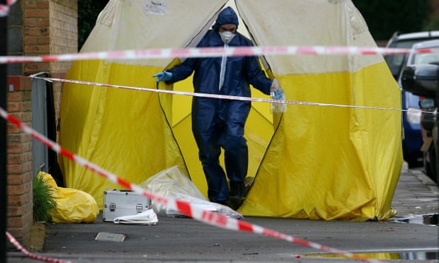 A scene of crime officer at work at the site of a fatal stabbing in London.