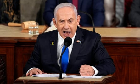 The Israeli prime minister, Benjamin Netanyahu, at a desk in front of a mic