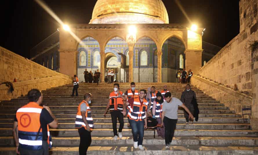 Médicos palestinos evacuam um ferido após confrontos no complexo da mesquita de al-Aqsa, em Jerusalém, em 10 de maio de 2021. 