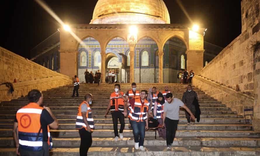 Médicos palestinos evacuam um ferido após confrontos no complexo da mesquita de al-Aqsa, em Jerusalém, em 10 de maio de 2021.