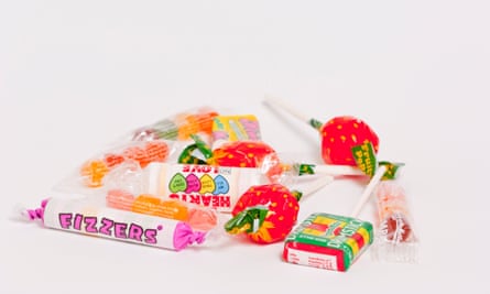 A close up of some candy sweets and lollipops on a white background