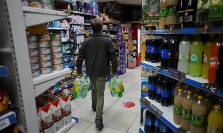 A man carries water bottles in a supermarket in Montevideo
