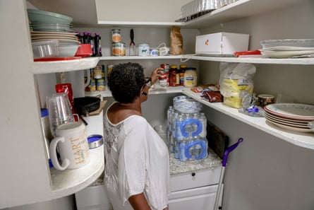 Kimberly Hart, 61, gets a can of mushrooms from her pantry to add to a chicken soup.