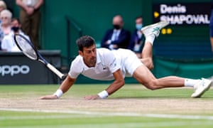 Novak Djokovic slips over during a rally.