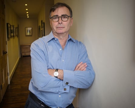 David Kogan posing for a photo while leaning against a wall in a corridor with arms folded