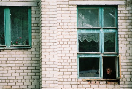 Outside shot shows a boy sitting at a window in the orphanage.