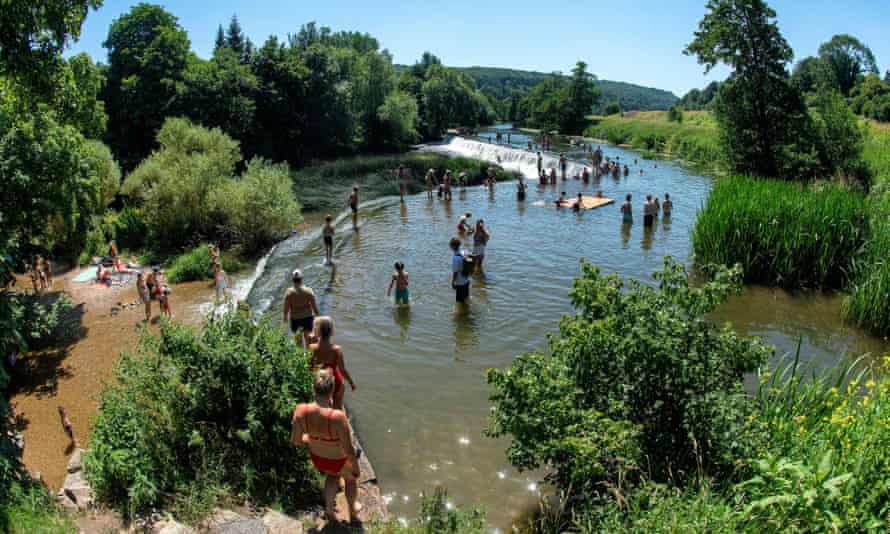 People enjoy the water at Warleigh Weir on the river Avon near Bath in Somerset.