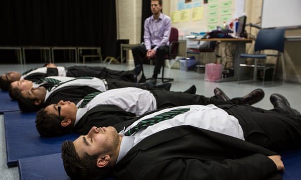 Teacher Dominic Morris and pupils practicising relaxation and meditation techniques.