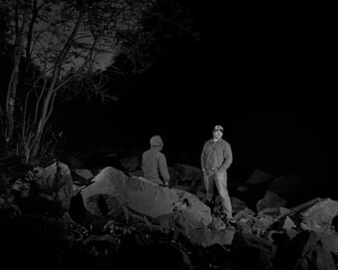 black and achromatic image of 2 group opinionated extracurricular astatine night, 1 pinch their backmost to nan camera and 1 looking up and to nan side