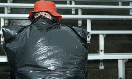 A fan looks on in a rain-soaked Foxborough.