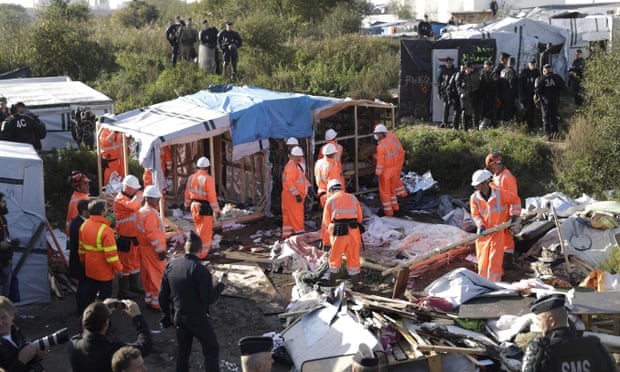 Workers demolish makeshift shelters in the Calais migrant camp (Photo Courtesy of The Guardian)