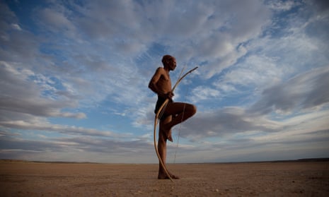 A bushman from the Khomani San community strikes a traditional pose in the Southern Kalahari desert, South Africa. The San still hunt animals as our common ancestors did.