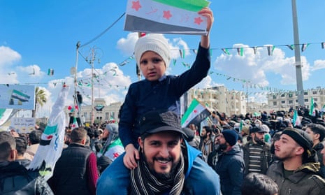 man and child with flag among protesters