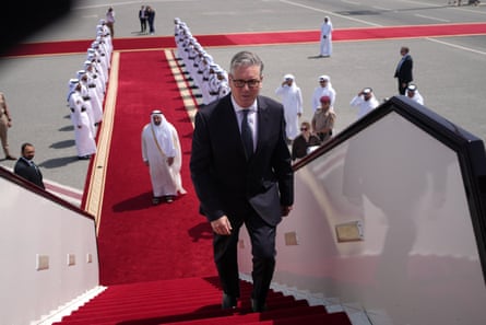 Keir Starmer at the top of a red carpet that leads all the way up the stairs into his plane