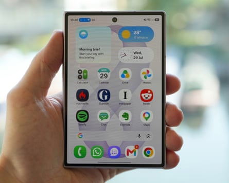 The Samsung Galaxy Z Fold 8 held in a hand closed with the display showing the home screen.