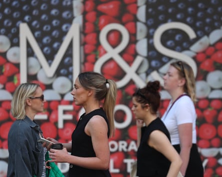 Shoppers pass a Marks & Spencer retail store in London in May