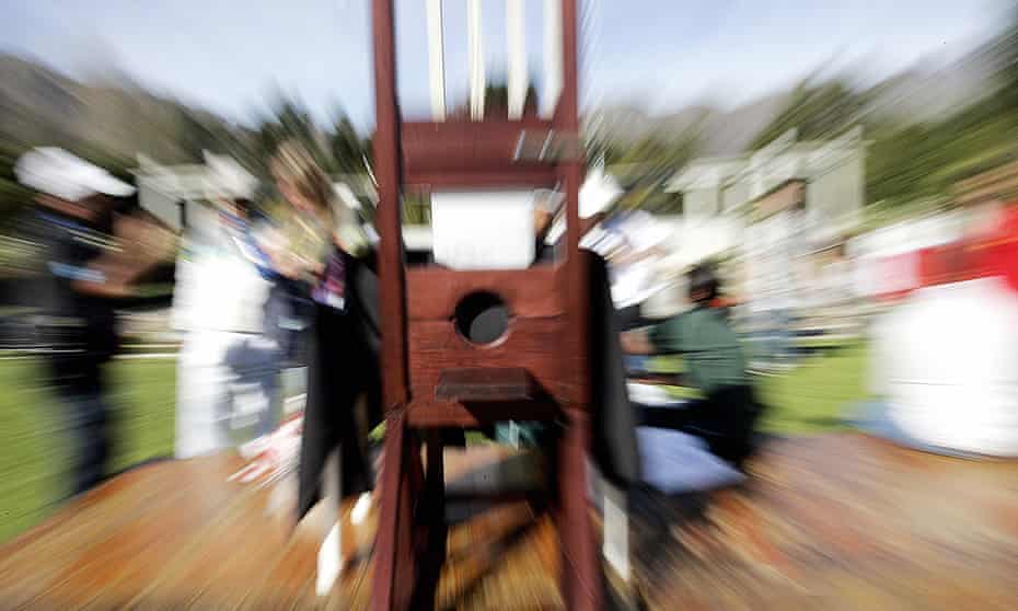 A guillotine amid blurred surroundings