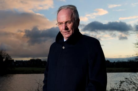 Sven-Göran Eriksson in 2010, wearing a dark coat and standing by a lake at dusk looking contemplative