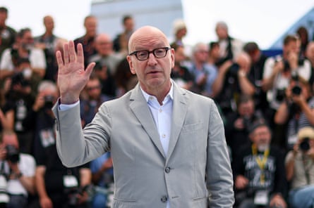 Steven Soderbergh in a white suit waving