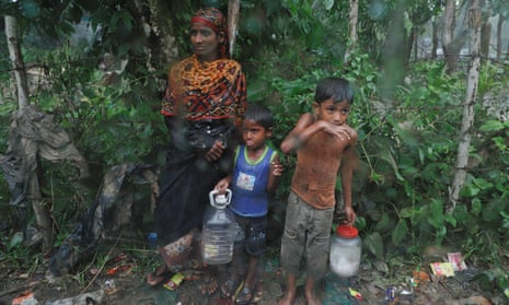 Rohingya refugees stand by the road in the rain outside their camp near Cox’s Bazar, Bangladesh
