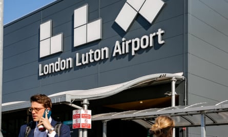 Passengers outside Luton airport terminal