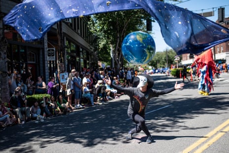 A performer acts as the moon to the Earth during the 30th annual Fremont Solstice Parade.