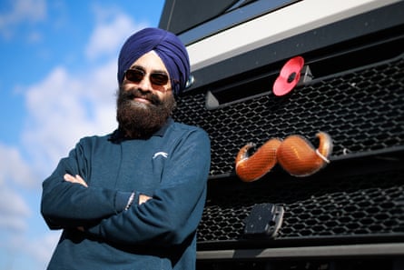 Sujinder Singh leans on the radiator of his lorry