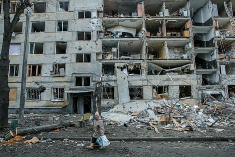A woman walks past a building destroyed by Russian army shelling in the second largest Ukrainian city of Kharkiv.
