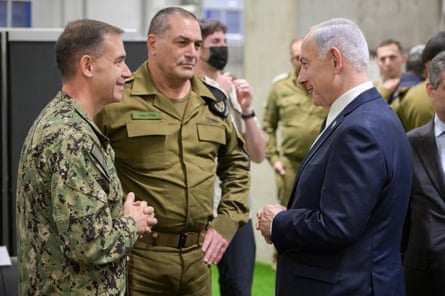 A suited Benjamin Netanyahu talking to Eyal Zamir and Adm Brad Cooper, both in military fatigues