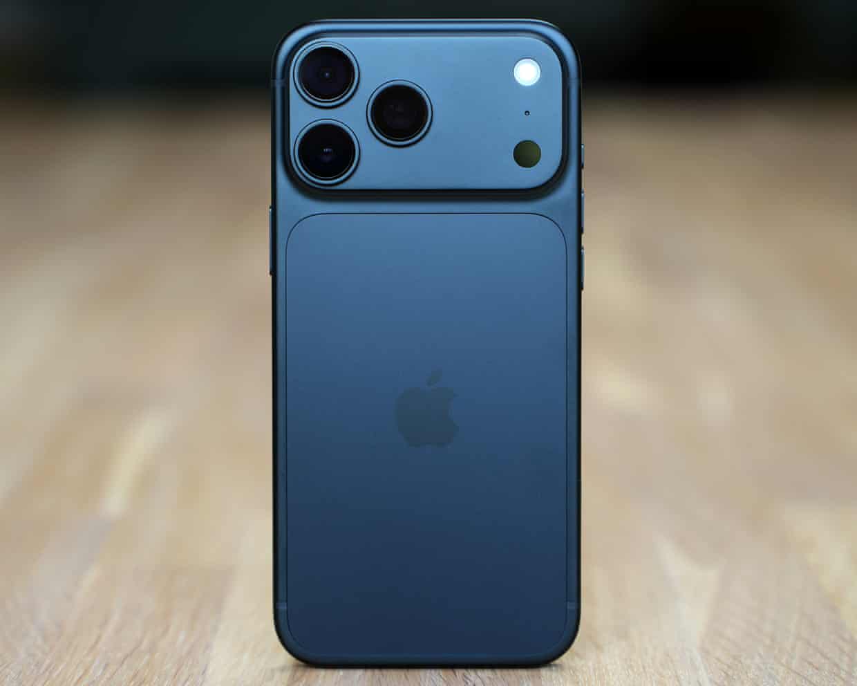 The back of the iPhone 18 Pro Max in black stood up on a wooden table
