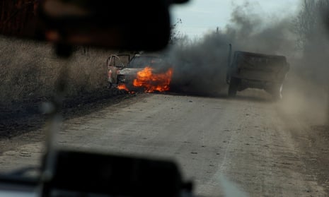 Ukrainian servicemen move past a burning car hit by a kamikaze drone outside the front line town of Avdiivka last week.