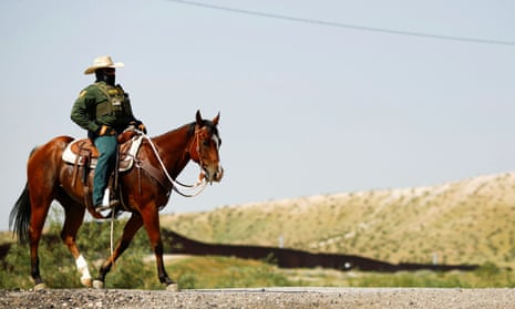 US border patrol agents on horseback are searching for migrants trying to enter the United States along the US-Mexico border.