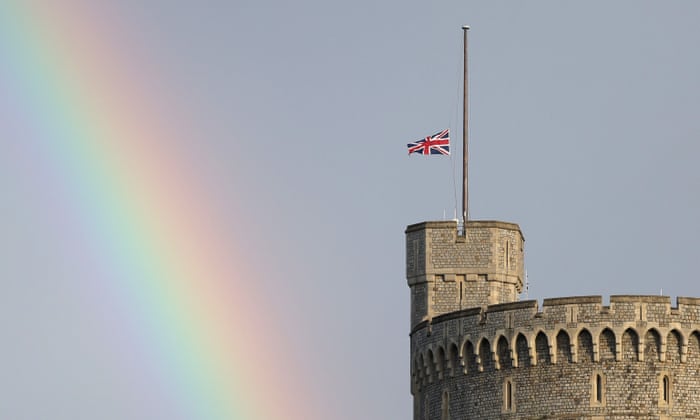 The Union flag is lowered on Windsor Castle as a rainbow covers the sky in Windsor, southern England.