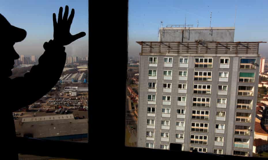 An asylum seeker looks from his window at the Glasgow high rise flats where a woman and two men fell to their death in 2010.