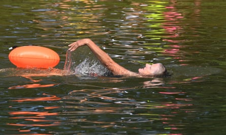 Swimmers cool down during the hot weather spell in a lake in Beckenham Place Park in south east London