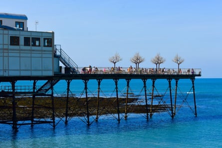 People eating and drinking outside at the end of Royal pier on a sunny day