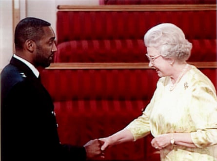 Leroy Logan shakes hands with the Queen after being awarded an MBE in 2000