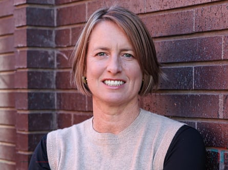 Rachel Jupp portrait: she is in her late 40s and has chin-length straight fair hair cut in a bob. She stands in front of a brick wall and is wearing a pale sleeveless jumper over a black top.